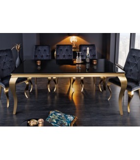 Piękny stół z czarnym blatem na złotych nogach do salonu urządzonego w stylu glamour.