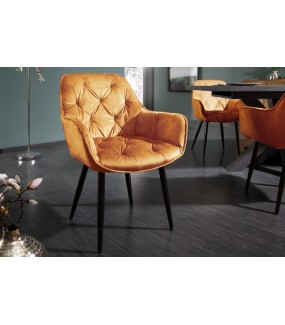 Wygodne krzesło tapicerowane w stylu chesterfield do salonu w stylu retro. Sprawdzi się w nowoczesnym pokoju dziennym.